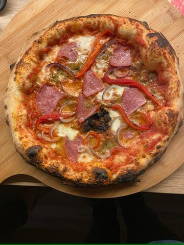 Freshly baked Fire & Flour artisan pizza on a wooden board